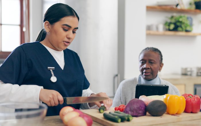 senior and caregiver preparing dinner