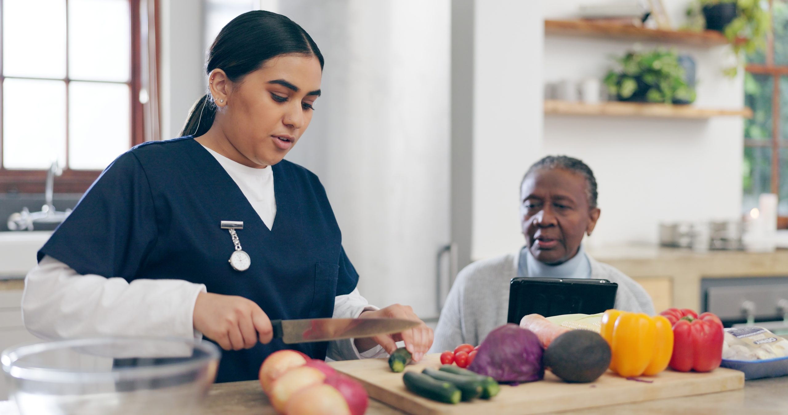 senior and caregiver preparing dinner